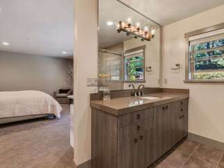 Step into luxury with this stunning bathroom, featuring a sleek vanity and a large mirror that reflects natural light.