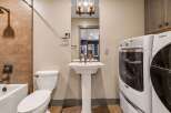 Step into this beautifully designed bathroom, featuring a modern pedestal sink and a convenient in-unit washer and dryer.