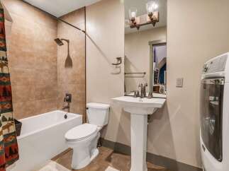 This charming bathroom features a combination of rustic and modern elements, creating a warm and inviting space.
