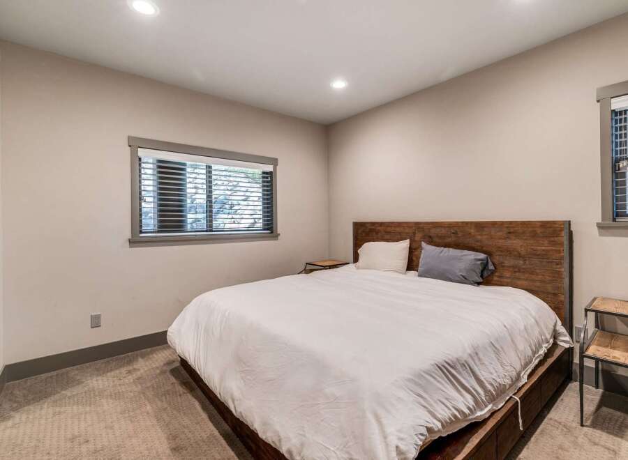This inviting bedroom features a cozy atmosphere with a comfortable bed and stylish wooden headboard.