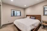 This inviting bedroom features a cozy atmosphere with a comfortable bed and stylish wooden headboard.