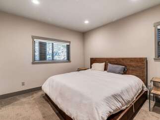 This inviting bedroom features a cozy atmosphere with a comfortable bed and stylish wooden headboard.