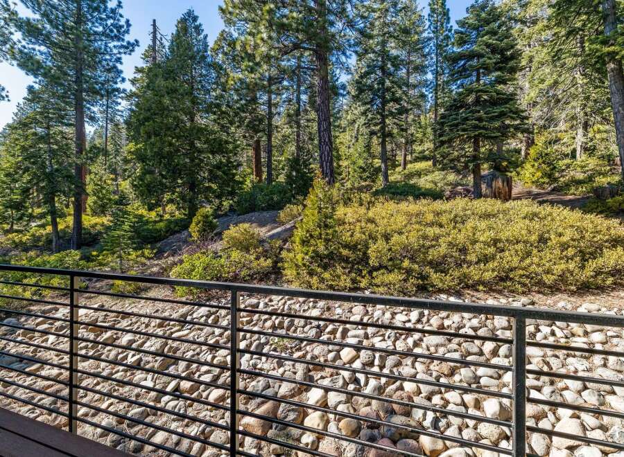 Enjoy the tranquility of nature from this stunning property! This home features a beautiful view of the surrounding forest, with a modern deck and a rock garden.