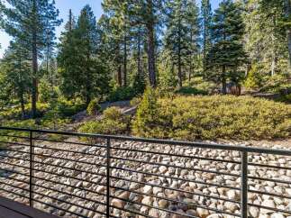 Enjoy the tranquility of nature from this stunning property! This home features a beautiful view of the surrounding forest, with a modern deck and a rock garden.