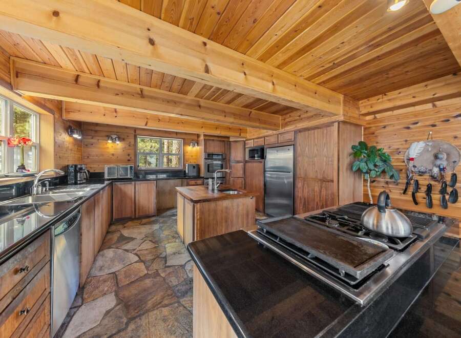 Step into this stunning kitchen, boasting a rustic charm with its wooden accents and stone flooring.