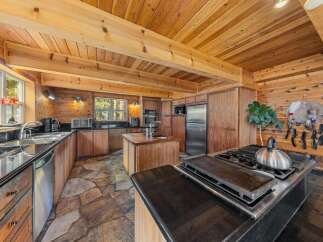 Step into this stunning kitchen, boasting a rustic charm with its wooden accents and stone flooring.