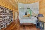 Step into this cozy bedroom featuring a unique wooden interior and a stylish canopy bed.