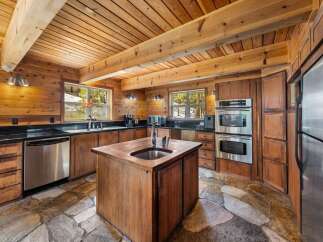 Step into this stunning kitchen, featuring a rustic design with wooden walls and ceiling, creating a warm and inviting atmosphere.
