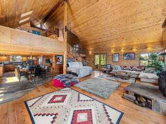 Step into luxury with this stunning log cabin home, boasting a spacious open floor plan and soaring ceilings.