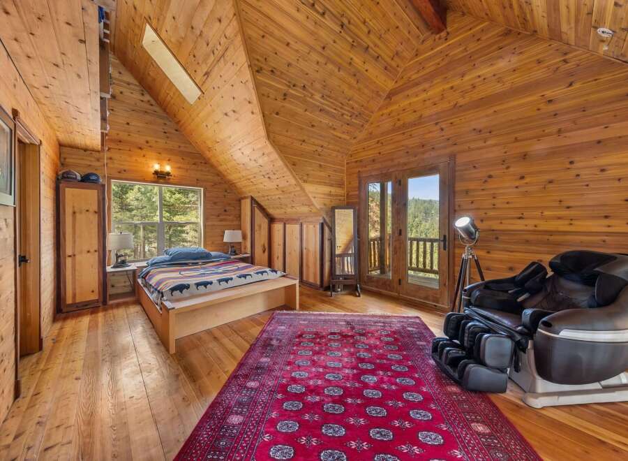 Step into this stunning bedroom retreat, featuring exquisite wood paneling and a vaulted ceiling that exudes warmth and character.