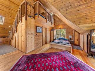 Step into rustic charm with this stunning bedroom featuring a unique loft space and warm wooden accents.