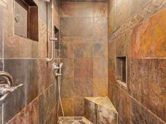 Step into luxury with this stunning shower featuring exquisite tile work and a sleek, modern design.