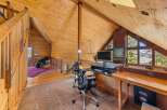 This stunning property features a unique, wood-paneled interior and a spacious loft area perfect for a home office.