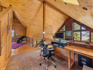 This stunning property features a unique, wood-paneled interior and a spacious loft area perfect for a home office.