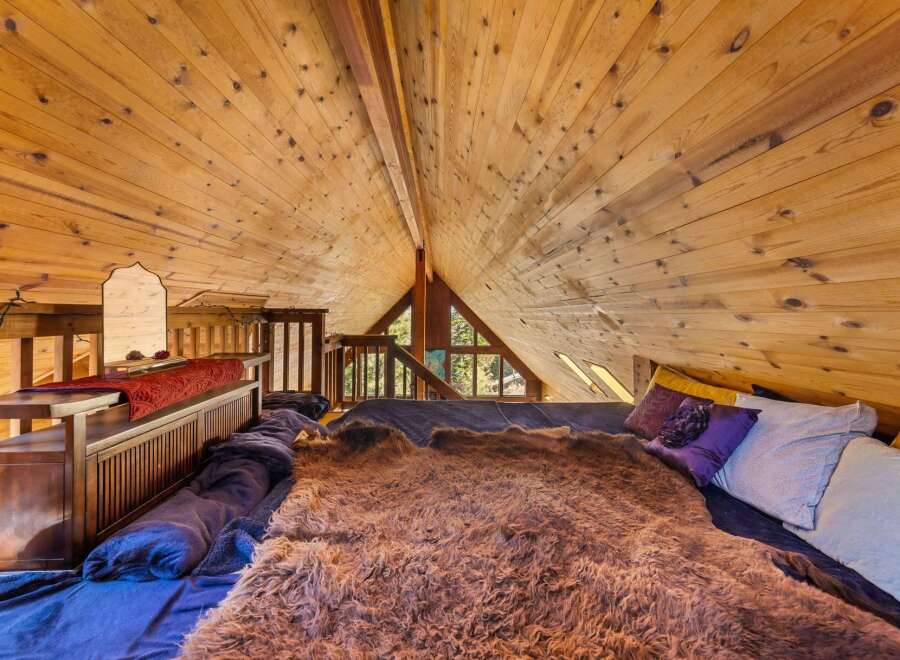 Discover the charm of this unique loft bedroom, featuring a stunning wooden ceiling that adds warmth and character.