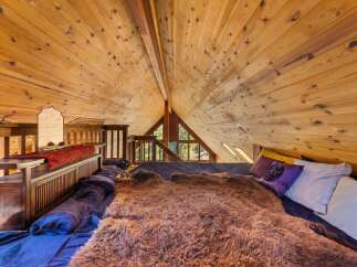 Discover the charm of this unique loft bedroom, featuring a stunning wooden ceiling that adds warmth and character.