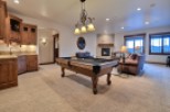 This stunning game room boasts a beautiful pool table, wet bar, and comfortable seating area, perfect for entertaining guests.