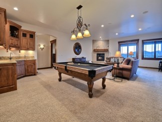 This stunning game room boasts a beautiful pool table, wet bar, and comfortable seating area, perfect for entertaining guests.