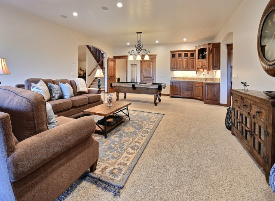 This stunning game room boasts a beautiful pool table, plush seating, and custom cabinetry.