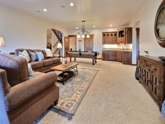 This stunning game room boasts a beautiful pool table, plush seating, and custom cabinetry.