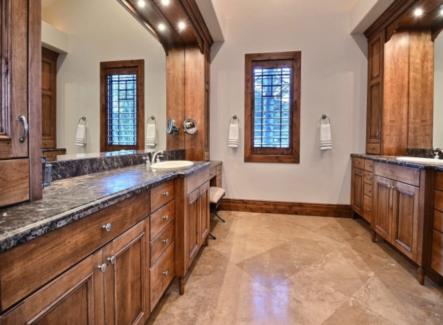 This luxurious bathroom boasts a stunning dark marble countertop, complemented by rich wood cabinetry.