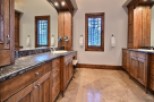 This luxurious bathroom boasts a stunning dark marble countertop, complemented by rich wood cabinetry.