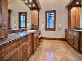 This luxurious bathroom boasts a stunning dark marble countertop, complemented by rich wood cabinetry.