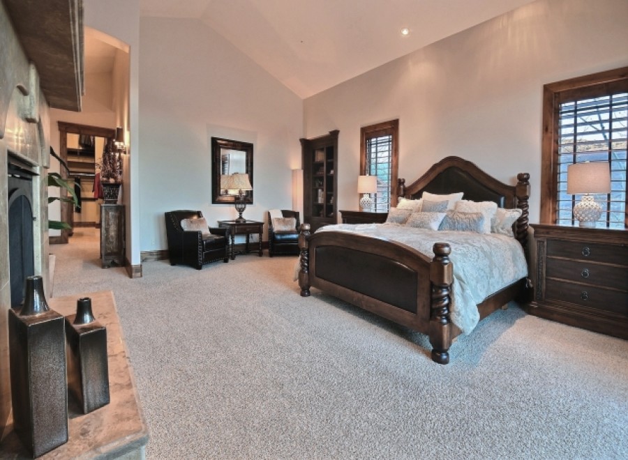 Luxurious master suite boasts a king-size bed, plush carpeting, and a fireplace.