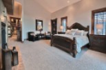 Luxurious master suite boasts a king-size bed, plush carpeting, and a fireplace.
