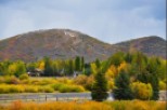 This picturesque property boasts stunning autumn foliage views, with vibrant yellow and orange hues dominating the landscape.