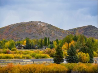 This picturesque property boasts stunning autumn foliage views, with vibrant yellow and orange hues dominating the landscape.