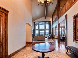 This stunning home boasts a grand two-story entryway with hardwood floors and a beautiful chandelier.