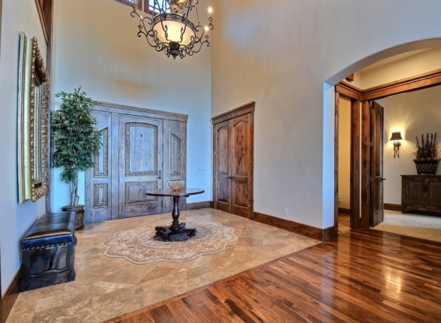 This stunning entryway boasts high ceilings, elegant hardwood floors, and exquisite double doors.