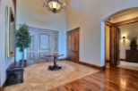 This stunning entryway boasts high ceilings, elegant hardwood floors, and exquisite double doors.
