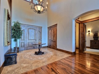 This stunning entryway boasts high ceilings, elegant hardwood floors, and exquisite double doors.