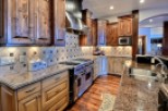 This stunning kitchen boasts beautiful dark wood cabinetry, granite countertops, and high-end stainless steel appliances.
