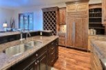 This stunning kitchen boasts a large island with granite countertops and stainless steel double sinks.