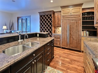 This stunning kitchen boasts a large island with granite countertops and stainless steel double sinks.
