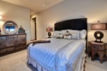 Luxurious master bedroom with a king-size bed, featuring a stunning silver comforter and plush pillows.