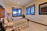 Cozy bedroom with large windows offering scenic views.