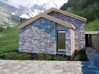 Discover the charm of this stunning stone-clad property nestled in a picturesque mountain setting.