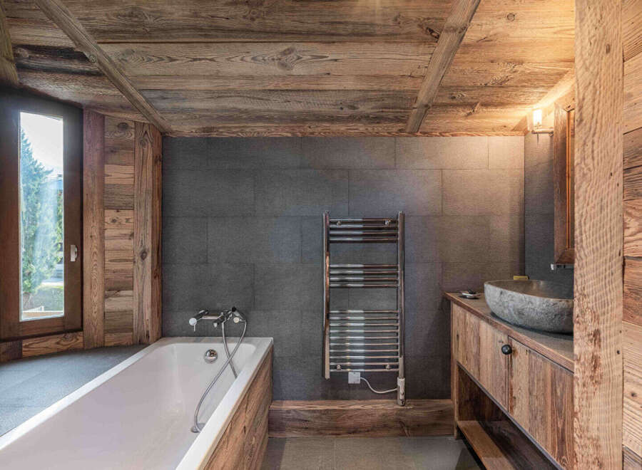 This stunning bathroom showcases a rustic design with wooden accents and a modern touch.