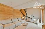 Discover modern living in this stunning property, featuring a stylish interior with a cozy sofa and a unique wooden wall.