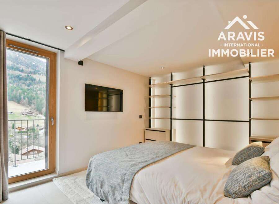 Experience luxury living in this stunning property, featuring a modern bedroom with a balcony offering breathtaking mountain views.