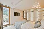 Experience luxury living in this stunning property, featuring a modern bedroom with a balcony offering breathtaking mountain views.