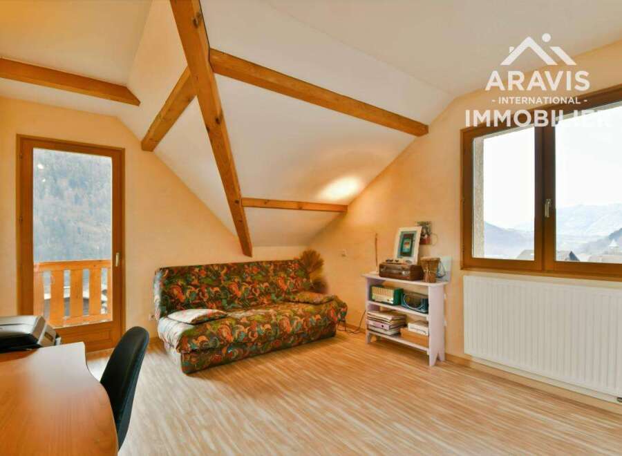 This charming property features a cozy living space with exposed wooden beams, creating a warm and inviting atmosphere.