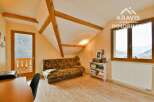 This charming property features a cozy living space with exposed wooden beams, creating a warm and inviting atmosphere.