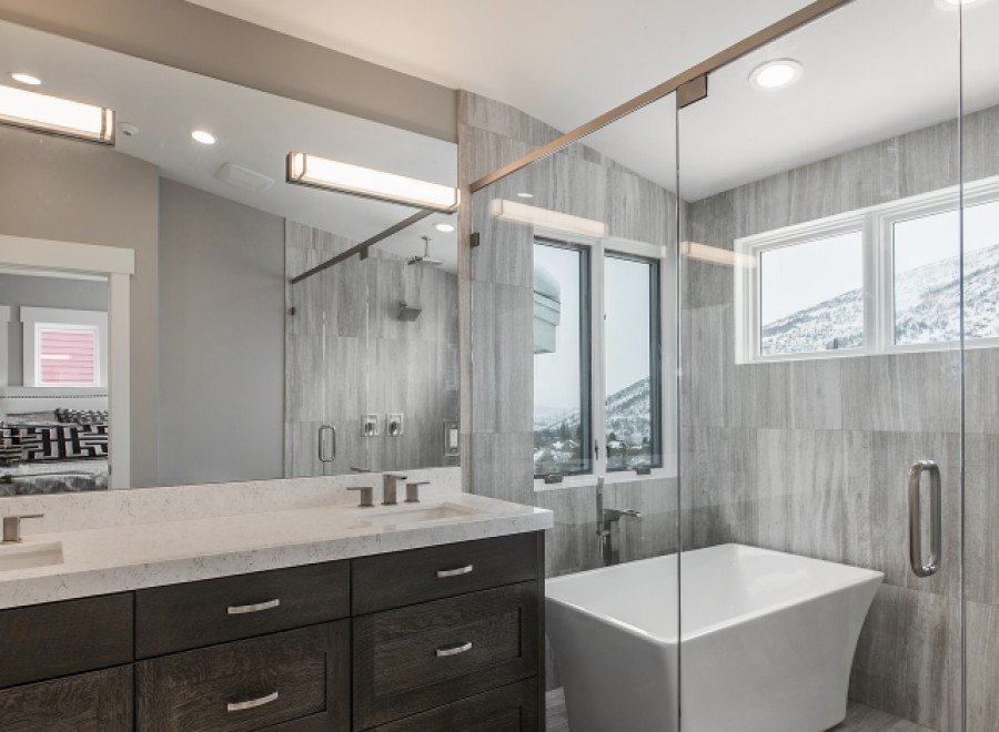 Luxurious bathroom boasts double vanity with quartz countertop and dark wood cabinets.