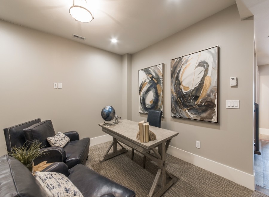 This stunning home office boasts a tranquil atmosphere with plush seating and large abstract art pieces.