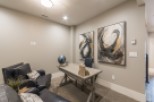 This stunning home office boasts a tranquil atmosphere with plush seating and large abstract art pieces.